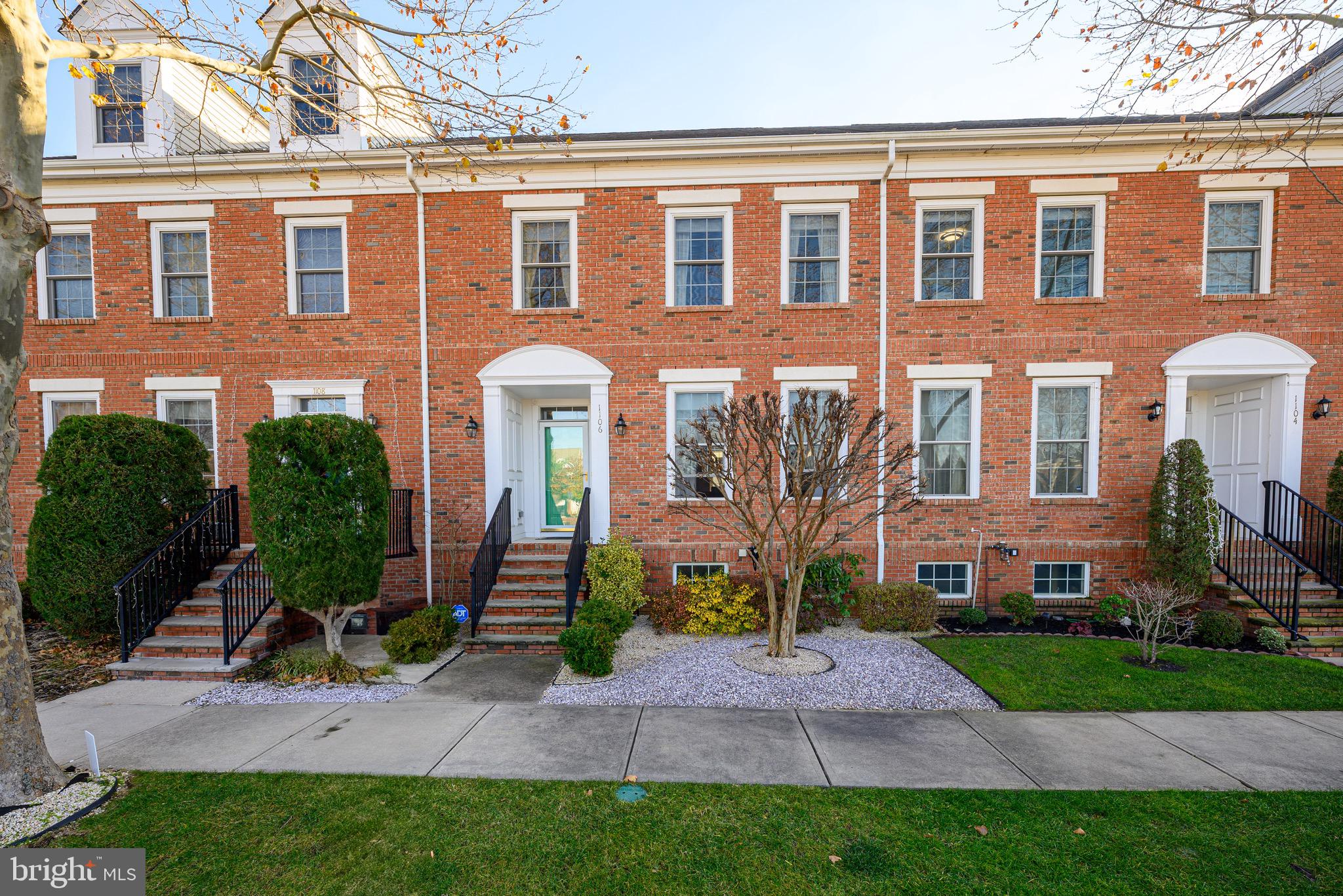 a front view of a house with a yard and potted plants