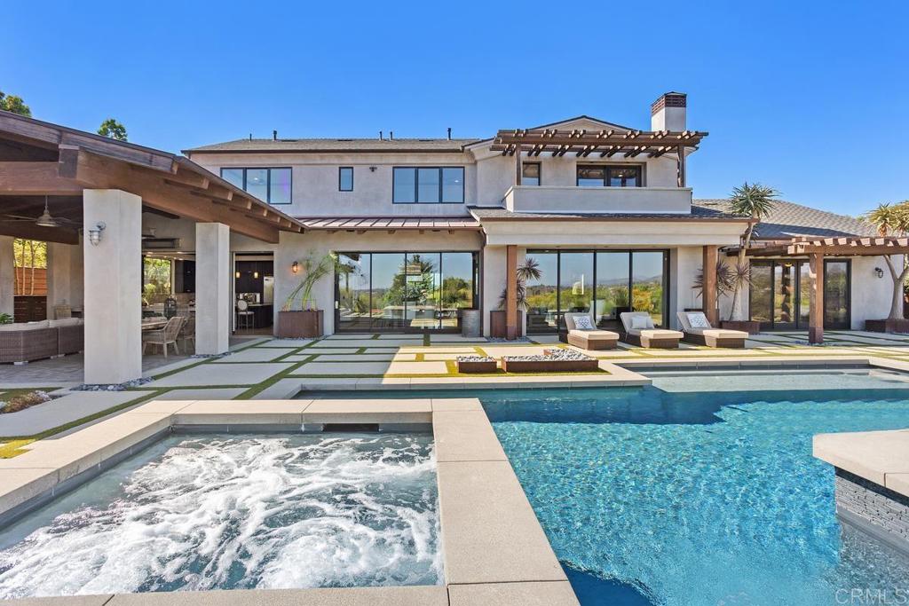 a view of a house with swimming pool and a dining table and chairs in patio