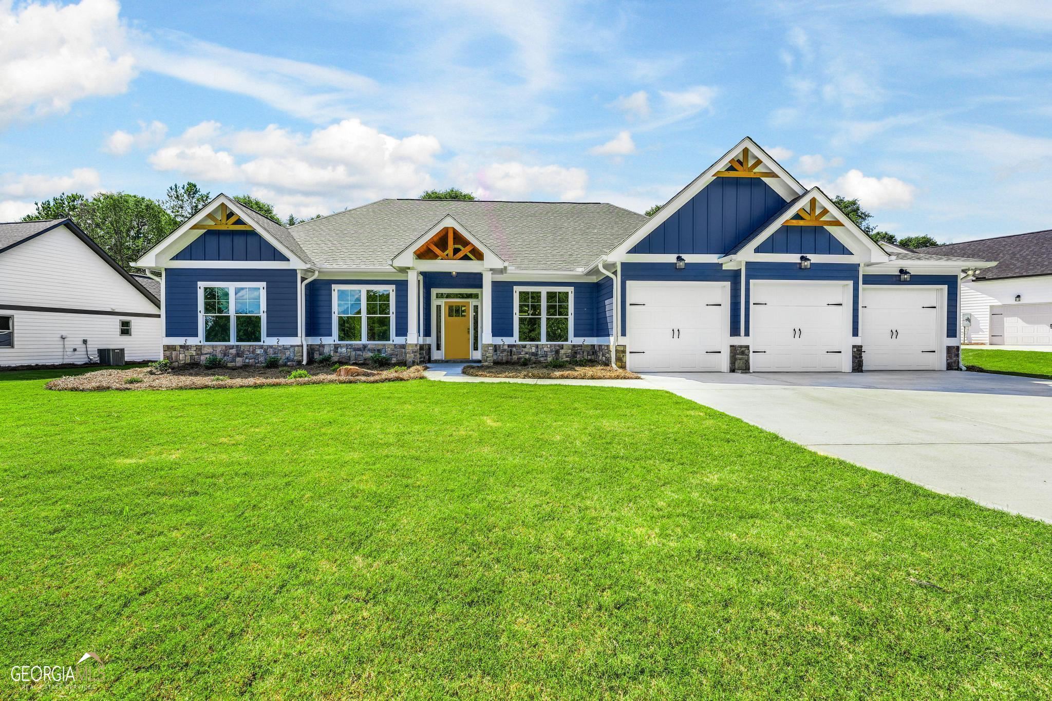 a front view of a house with a yard and trees