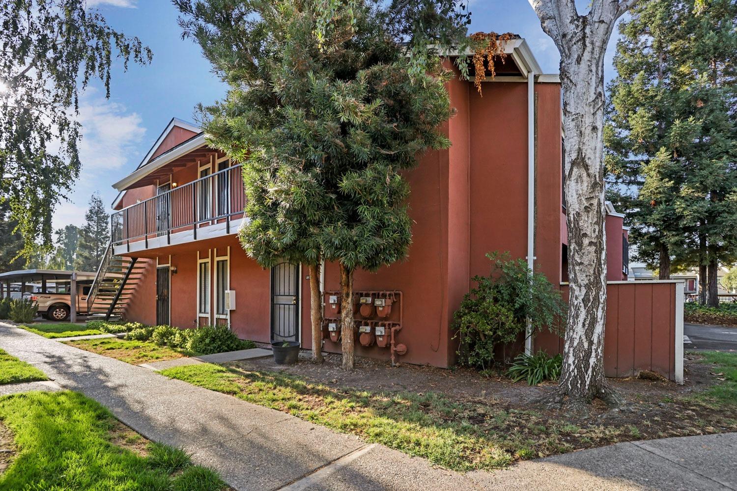 front view of house with a yard and trees