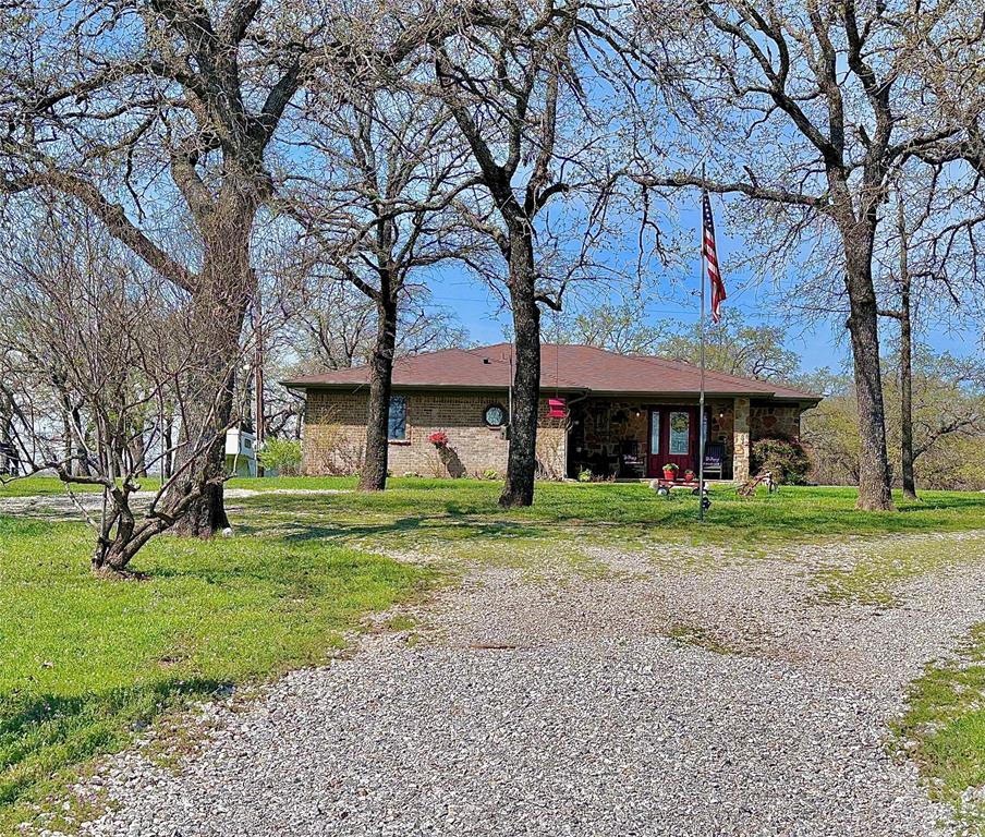 a view of a house with a yard and large tree