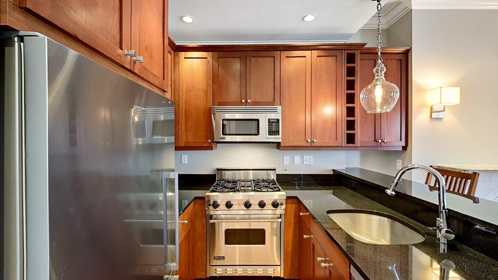 a kitchen with stainless steel appliances granite countertop a sink stove and refrigerator