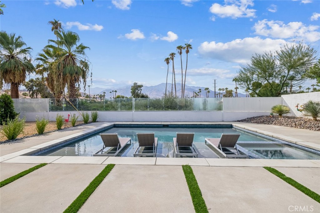 a view of swimming pool with outdoor seating and plants