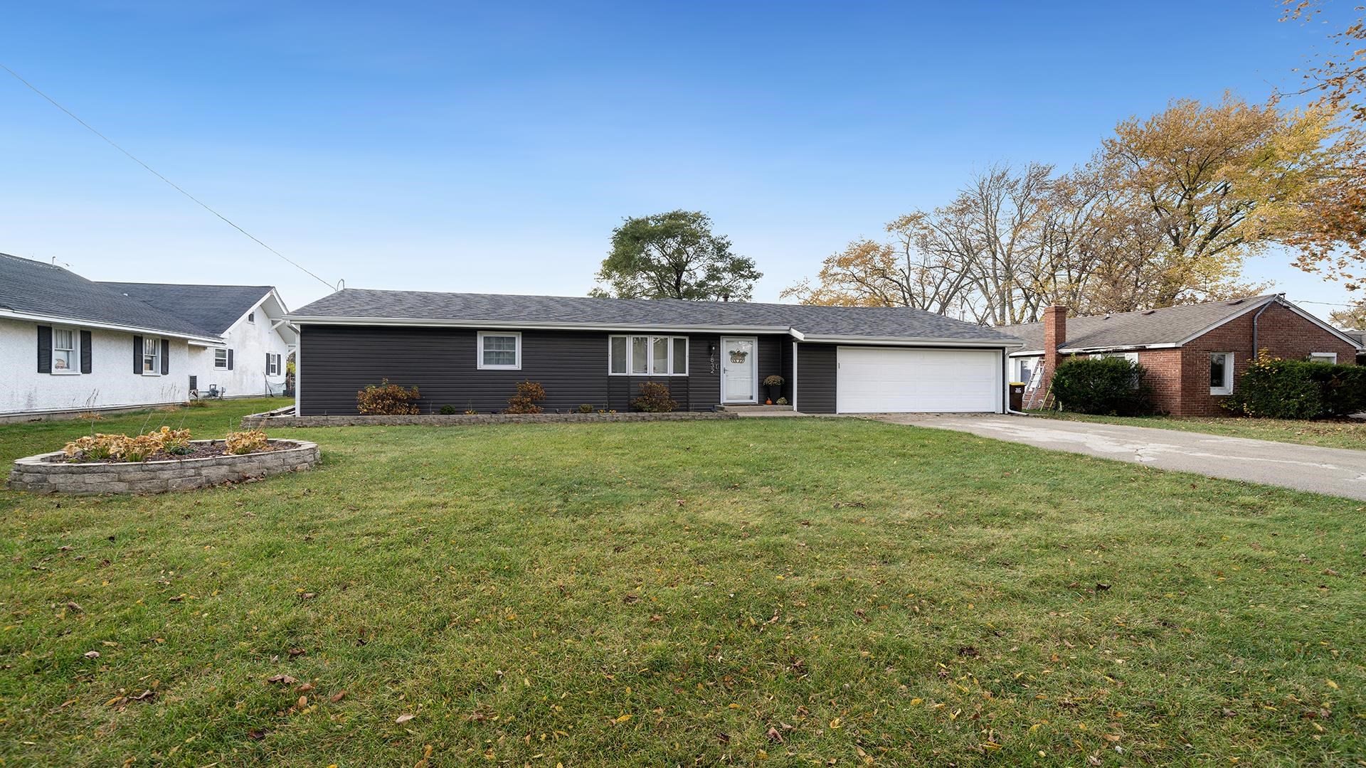 a front view of a house with a garden and yard