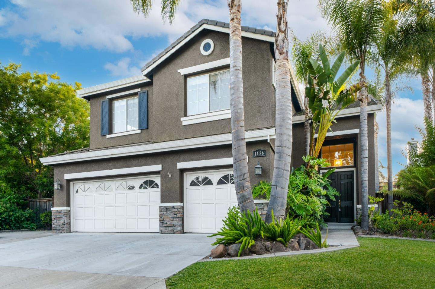 a front view of a house with a yard and garage