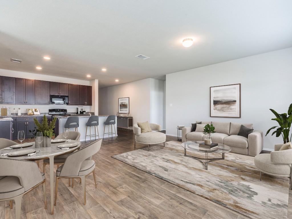 a living room with lots of furniture and view of kitchen