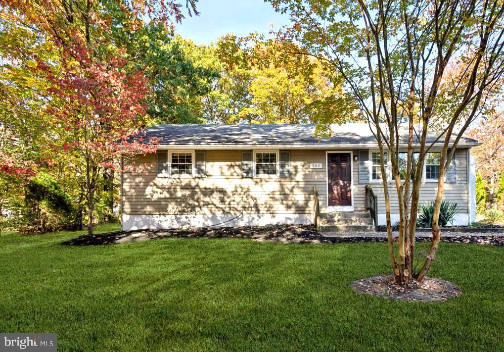 a front view of a house with a garden and trees