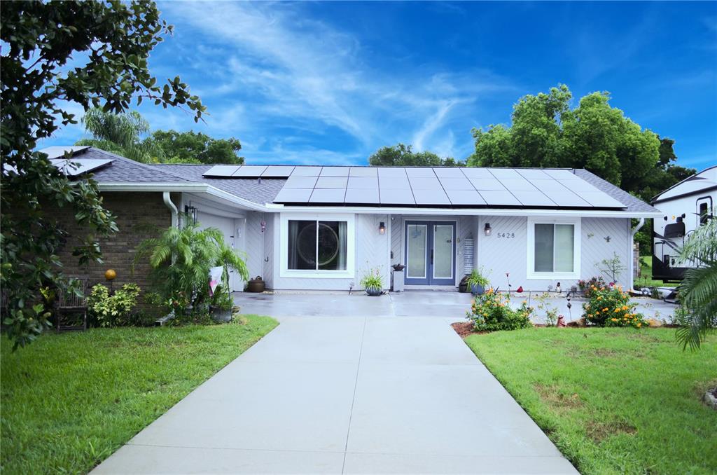 a front view of a house with a garden and plants