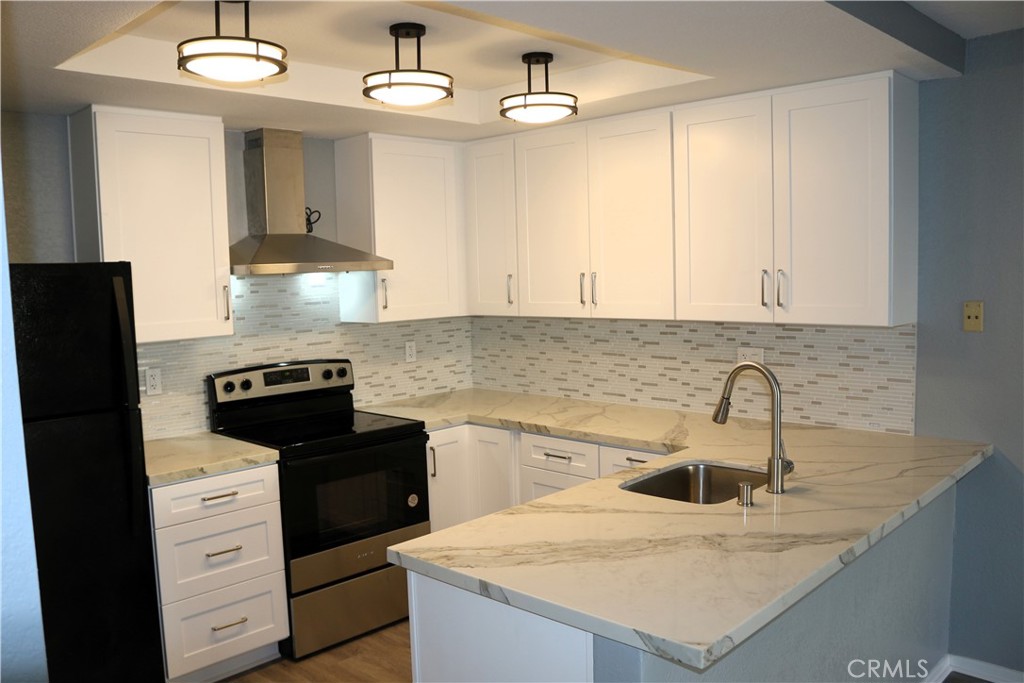 a kitchen with granite countertop a sink a stove and refrigerator