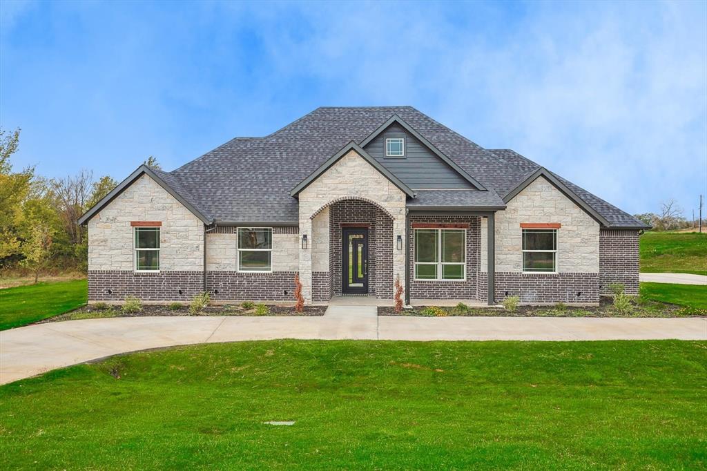 a front view of a house with yard and green space