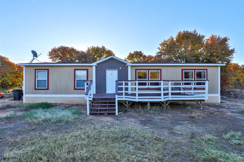 a backyard of a house with wooden deck and furniture