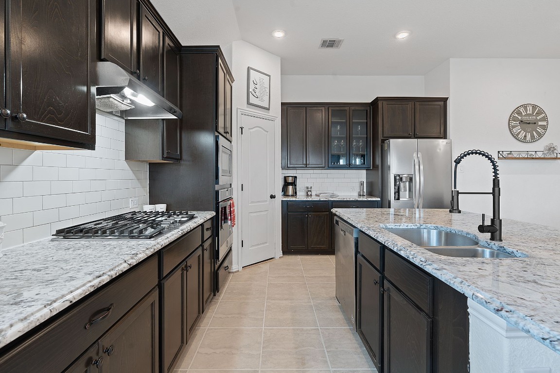 a kitchen with stainless steel appliances granite countertop a sink stove and refrigerator