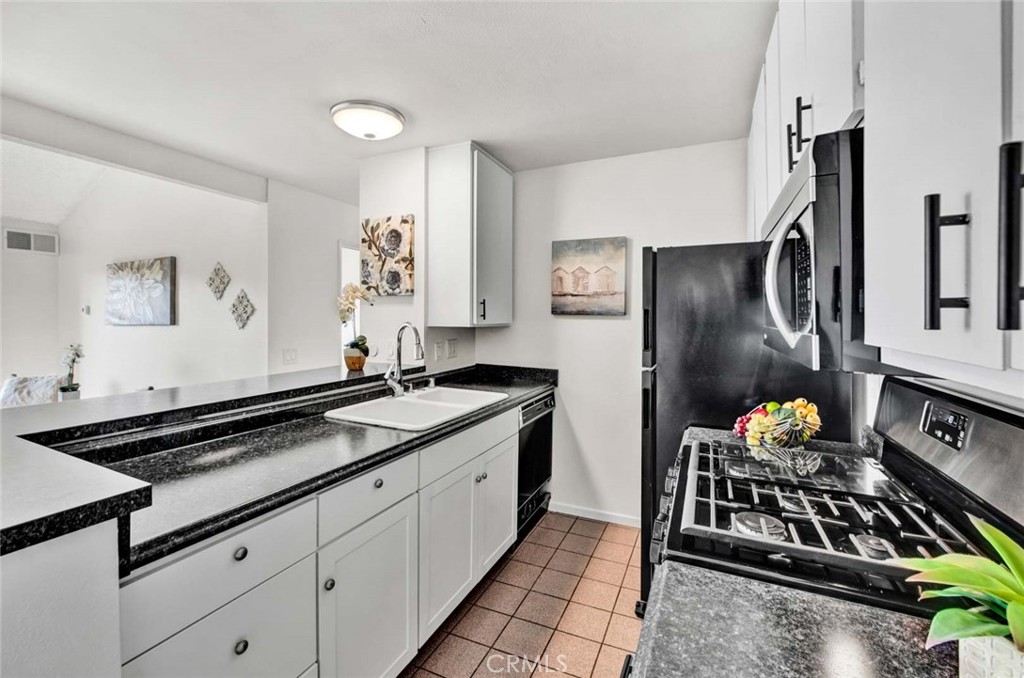 a kitchen with stainless steel appliances a sink stove and refrigerator