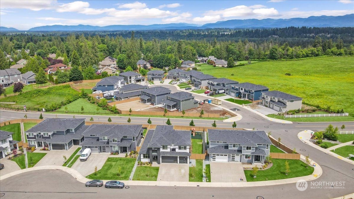 an aerial view of residential houses with outdoor space and ocean view