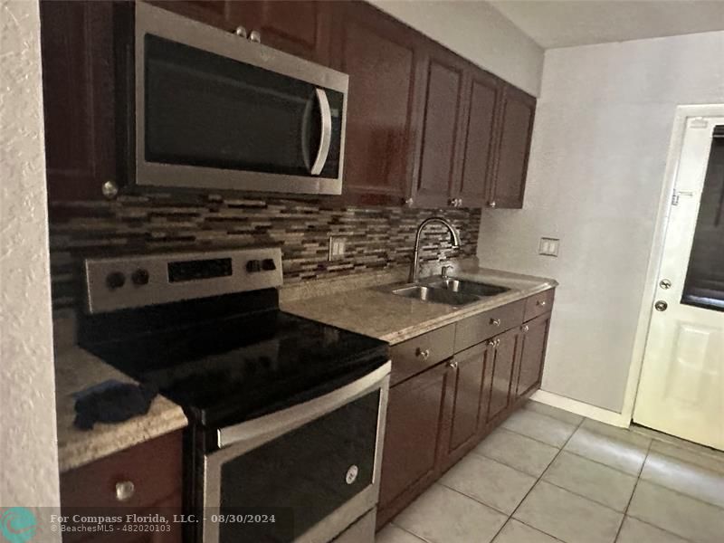 a kitchen with stainless steel appliances granite countertop a stove and a microwave