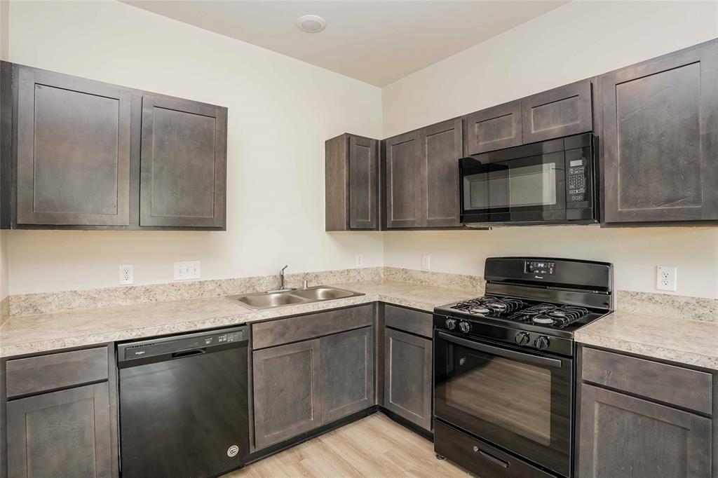 a kitchen with sink a microwave and cabinets