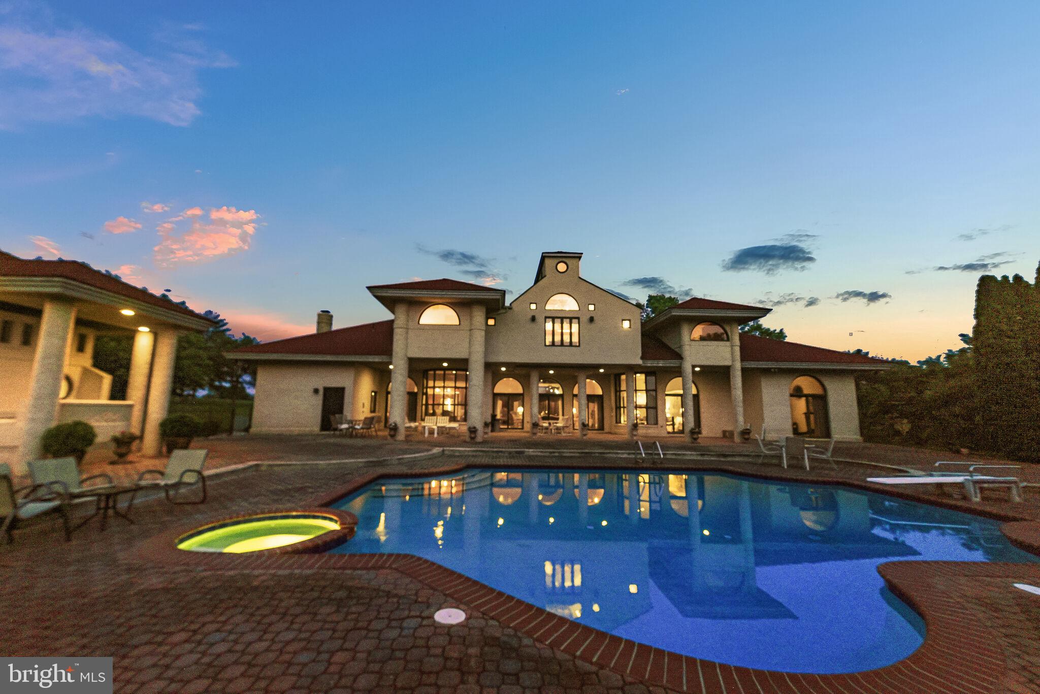 a view of a house with pool and chairs