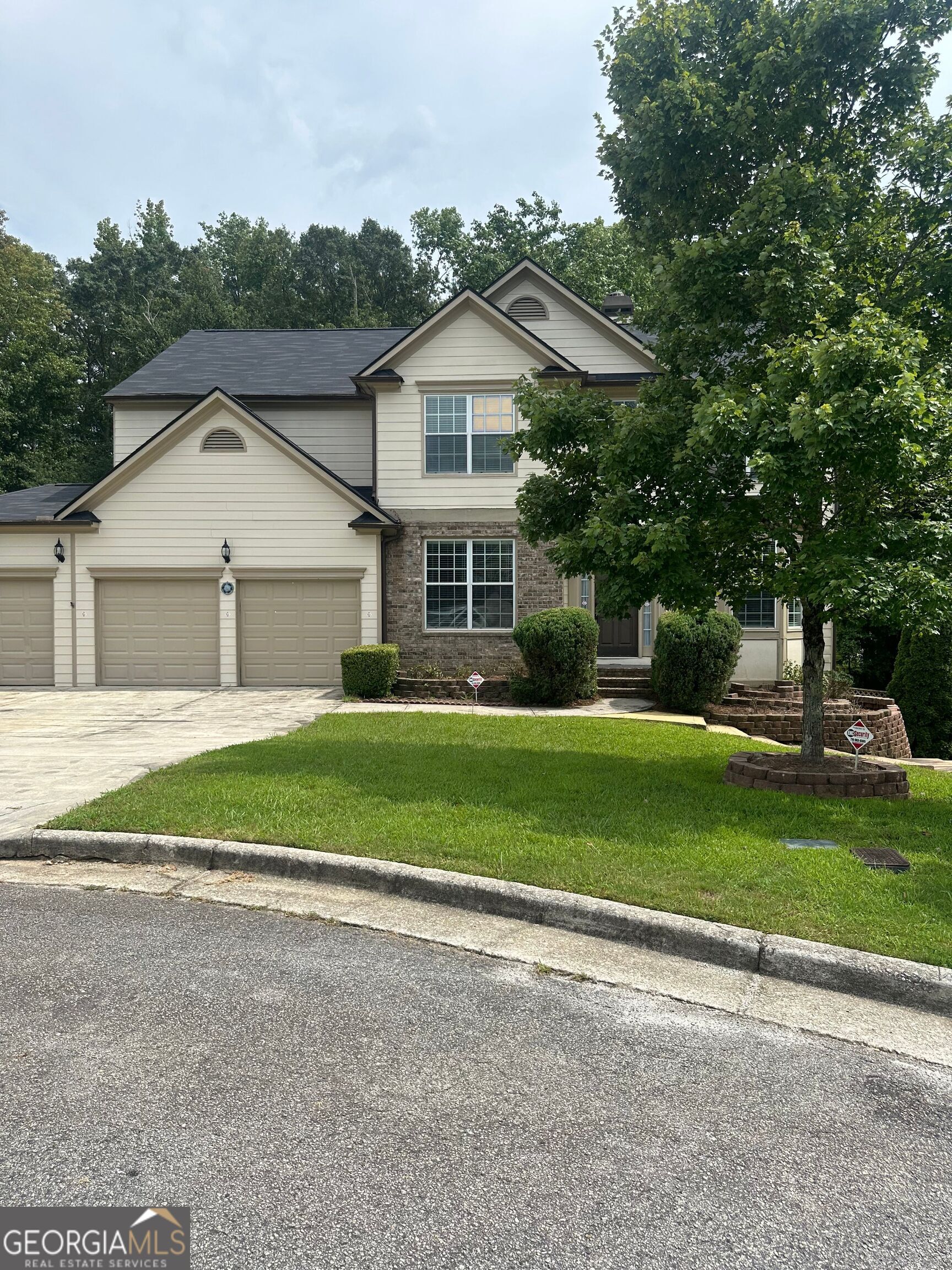 a front view of a house with a garden and yard