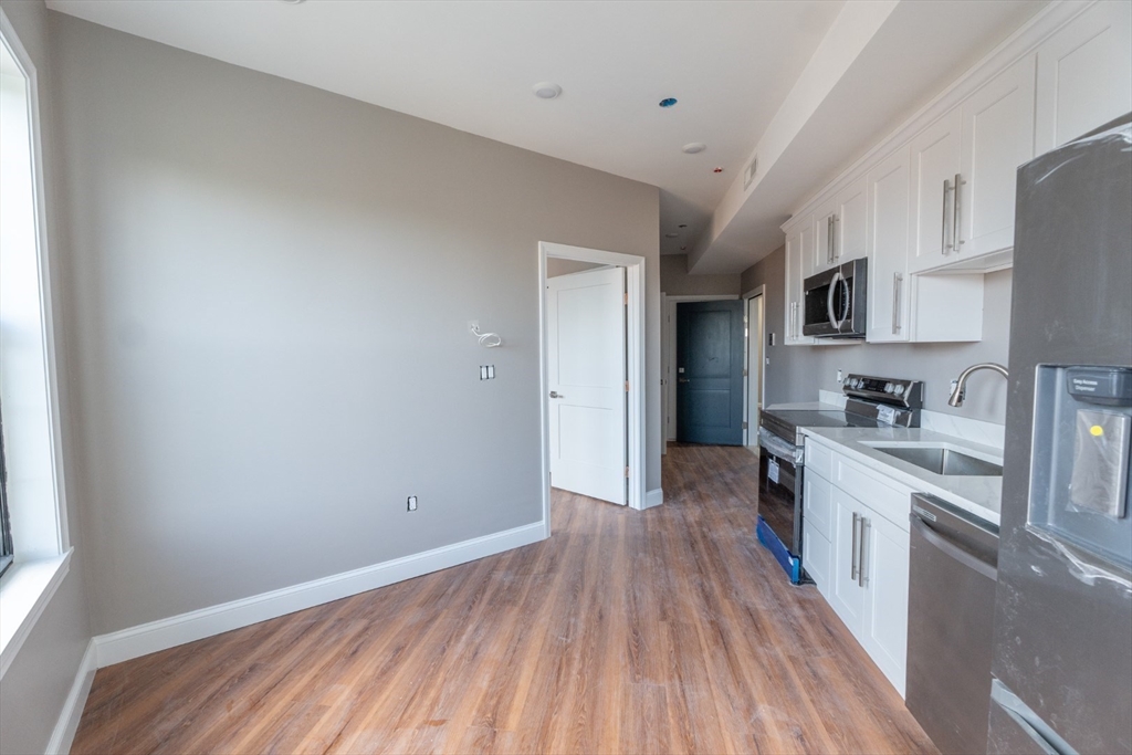 a view of a kitchen with a sink stove cabinets and a window