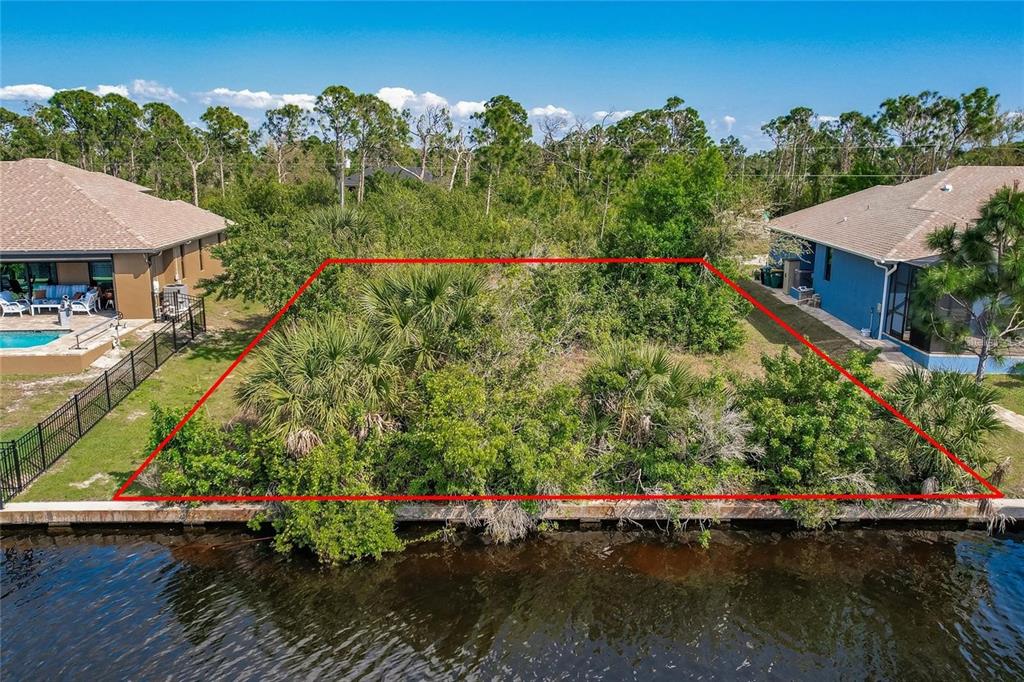 an aerial view of a house with a yard and lake view