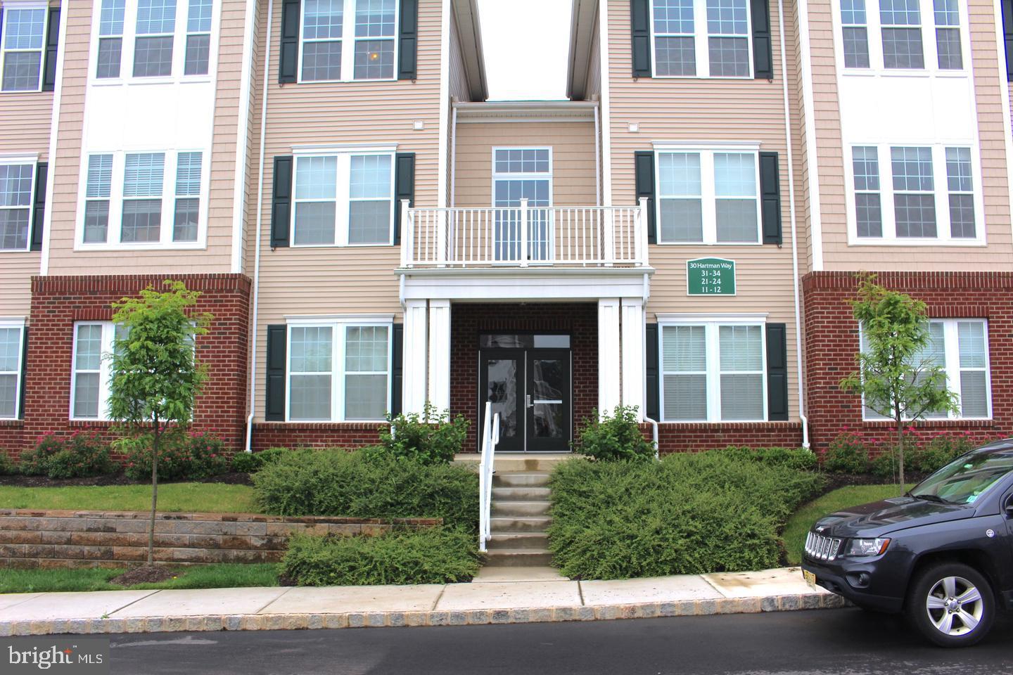 a front view of a house with a yard and parking space