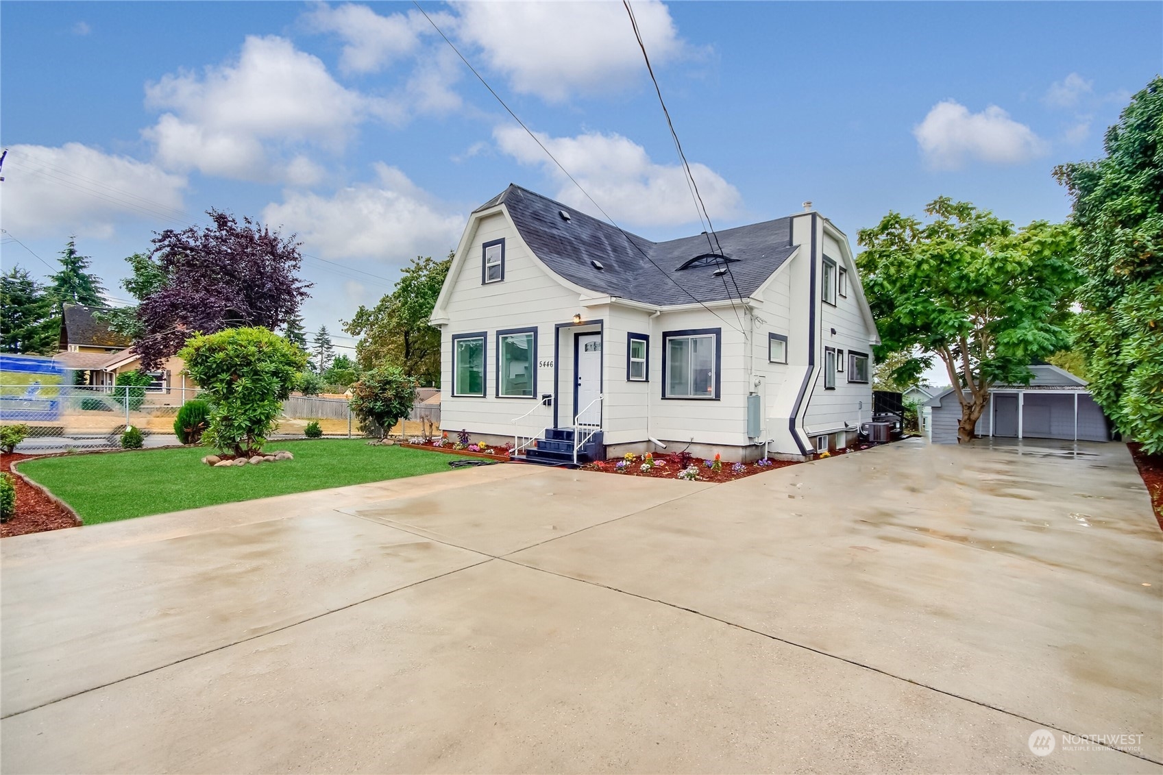 a view of a house with a yard and large tree