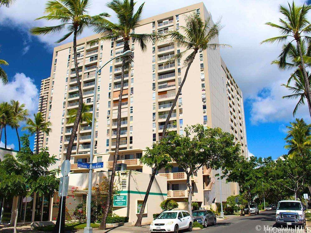 a view of a city with tall buildings and a cars park side of a road