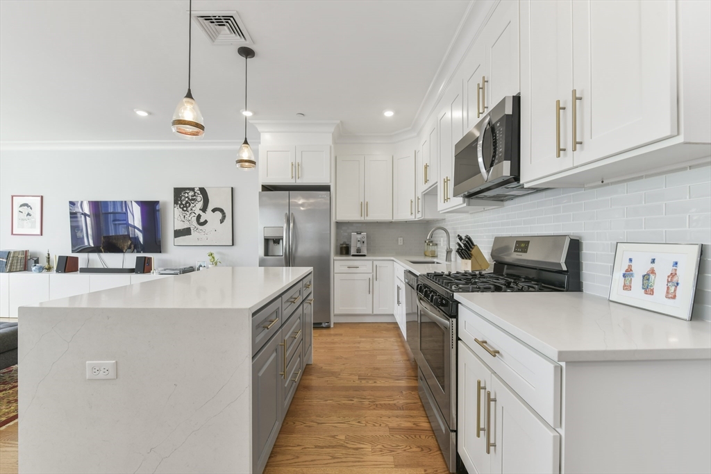 a kitchen with stainless steel appliances kitchen island a sink and a refrigerator