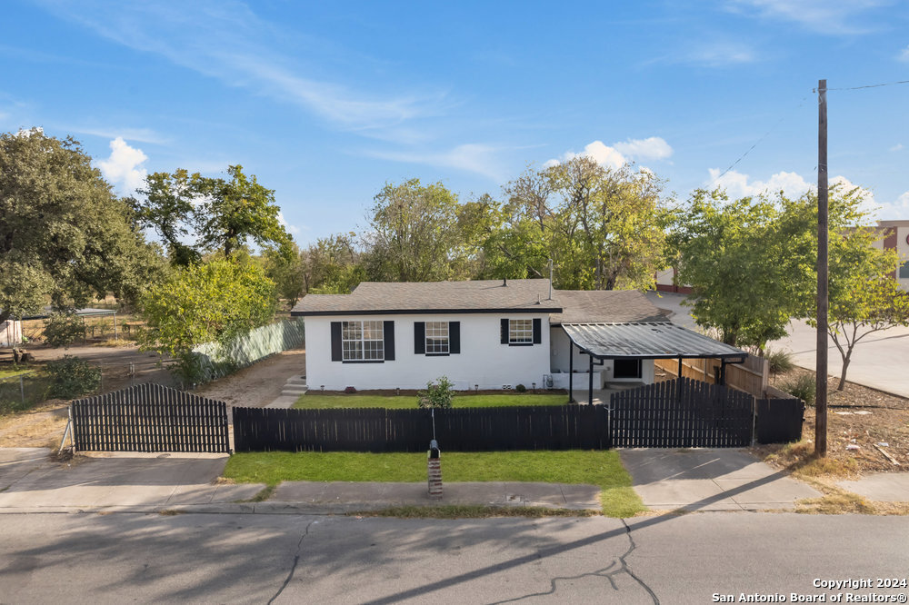 a view of a house with a backyard and a tree