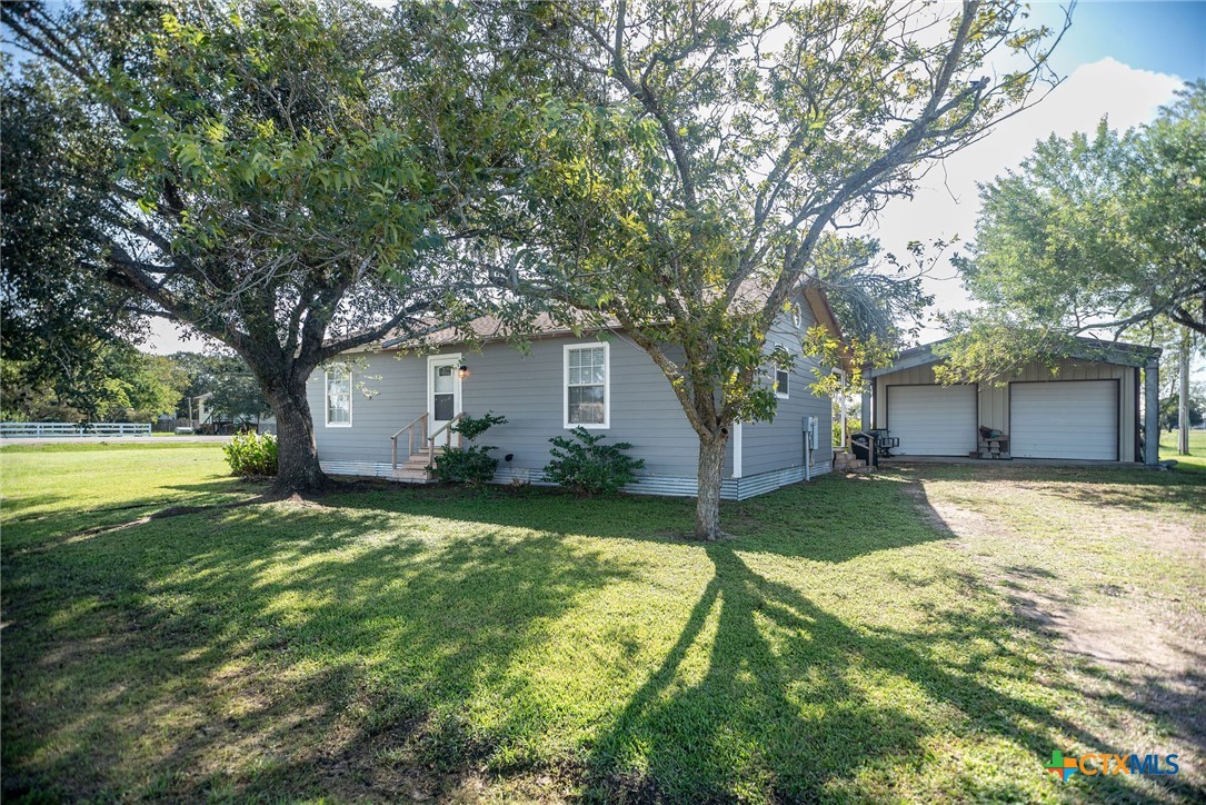 a view of a house with a yard and tree s