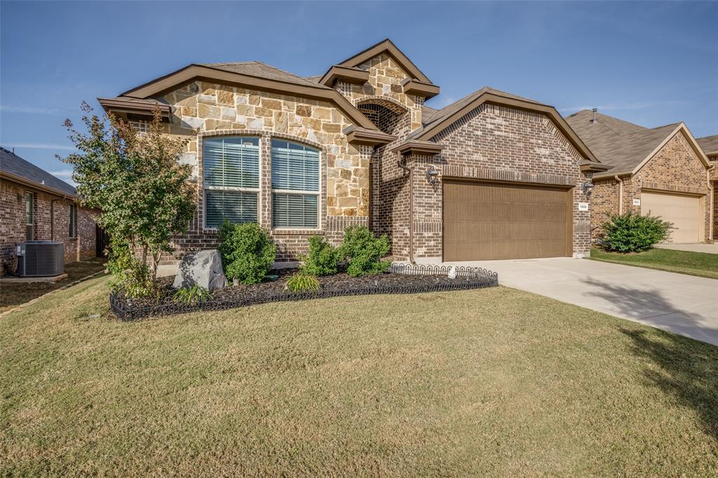 View of front of property with a garage and a front lawn