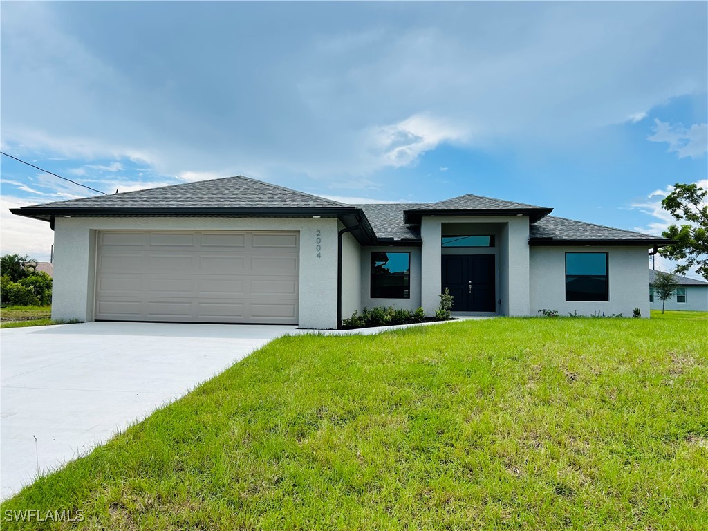 a front view of a house with a yard and garage