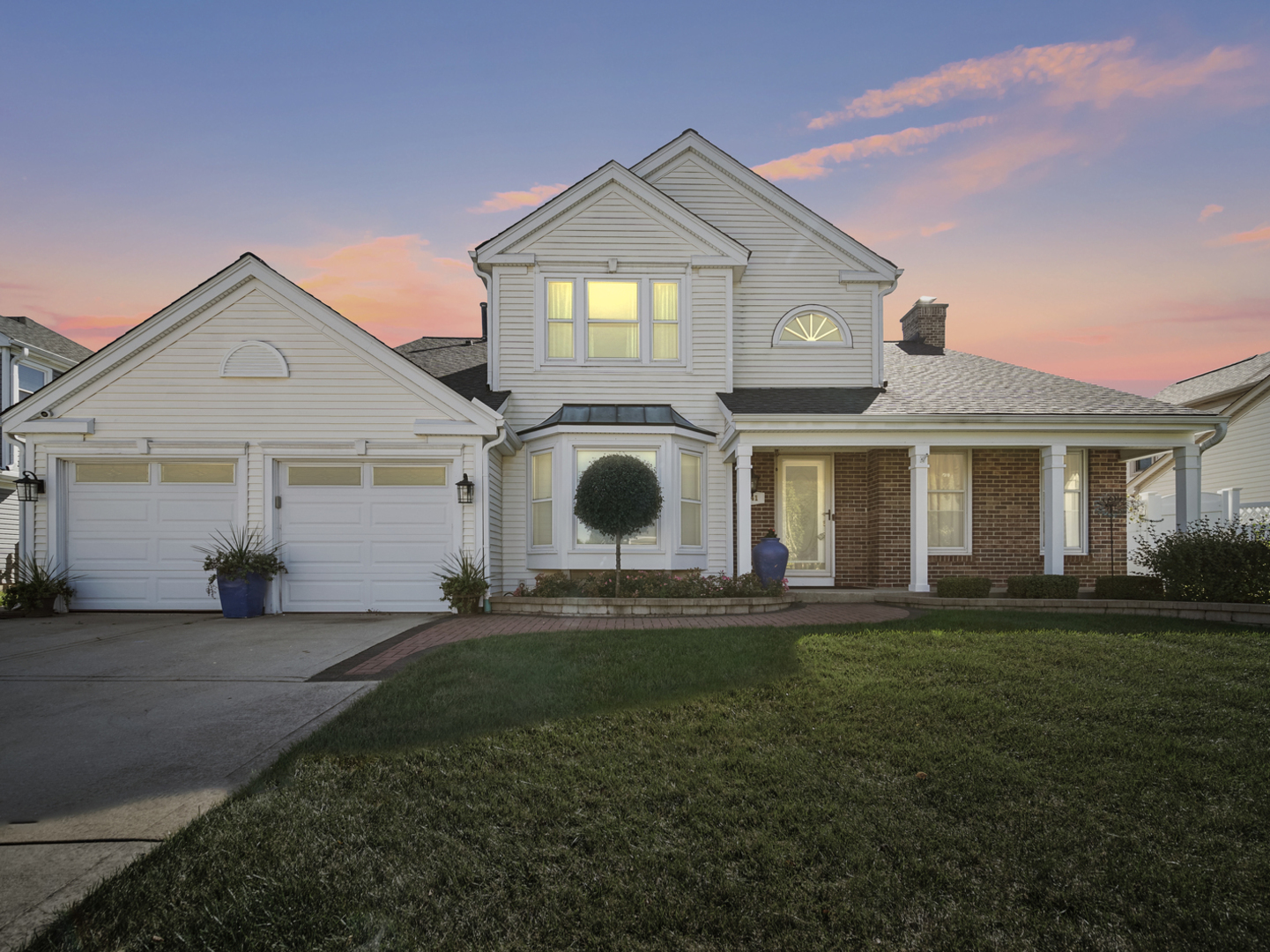 a front view of a house with a garden and yard