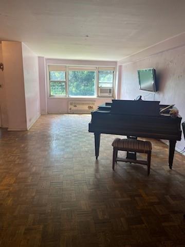 Misc room featuring radiator, cooling unit, and dark parquet floors