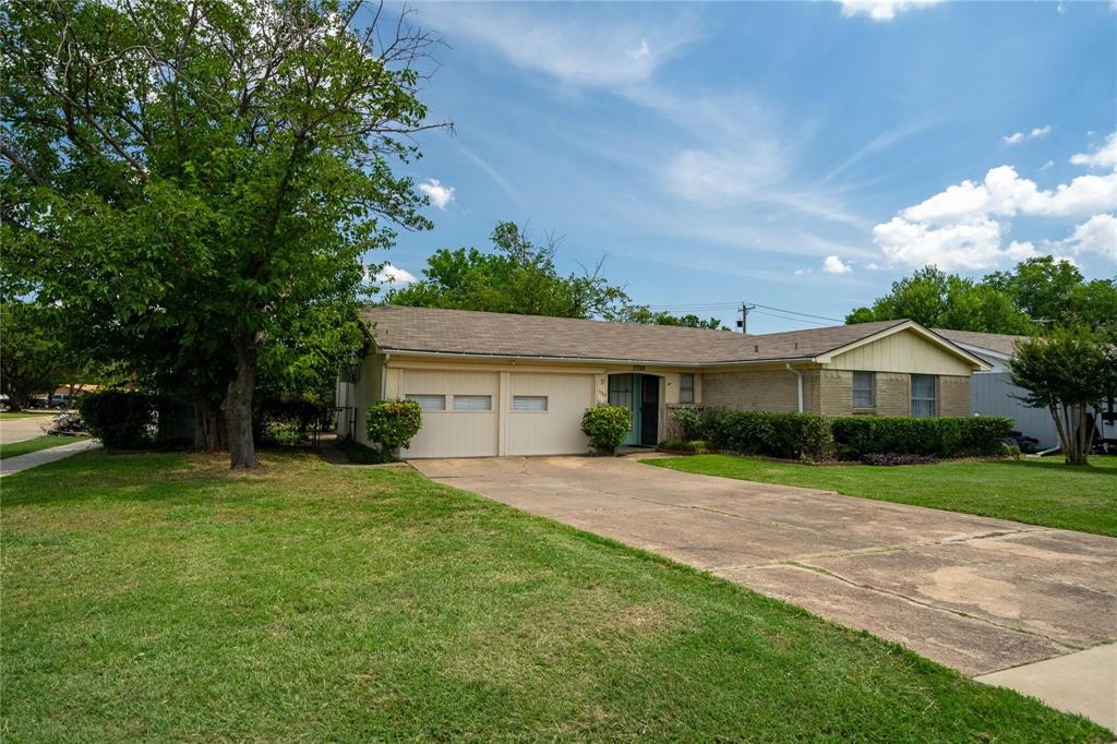 a front view of a house with a yard and trees