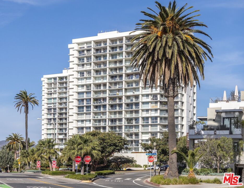 a front view of a building with palm trees