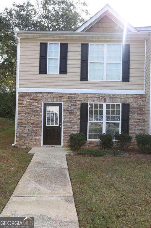 front view of a brick house with a yard