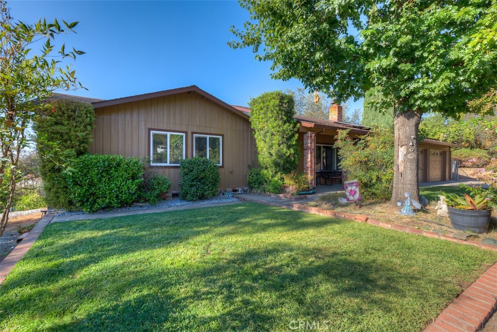 a front view of a house with a yard and potted plants