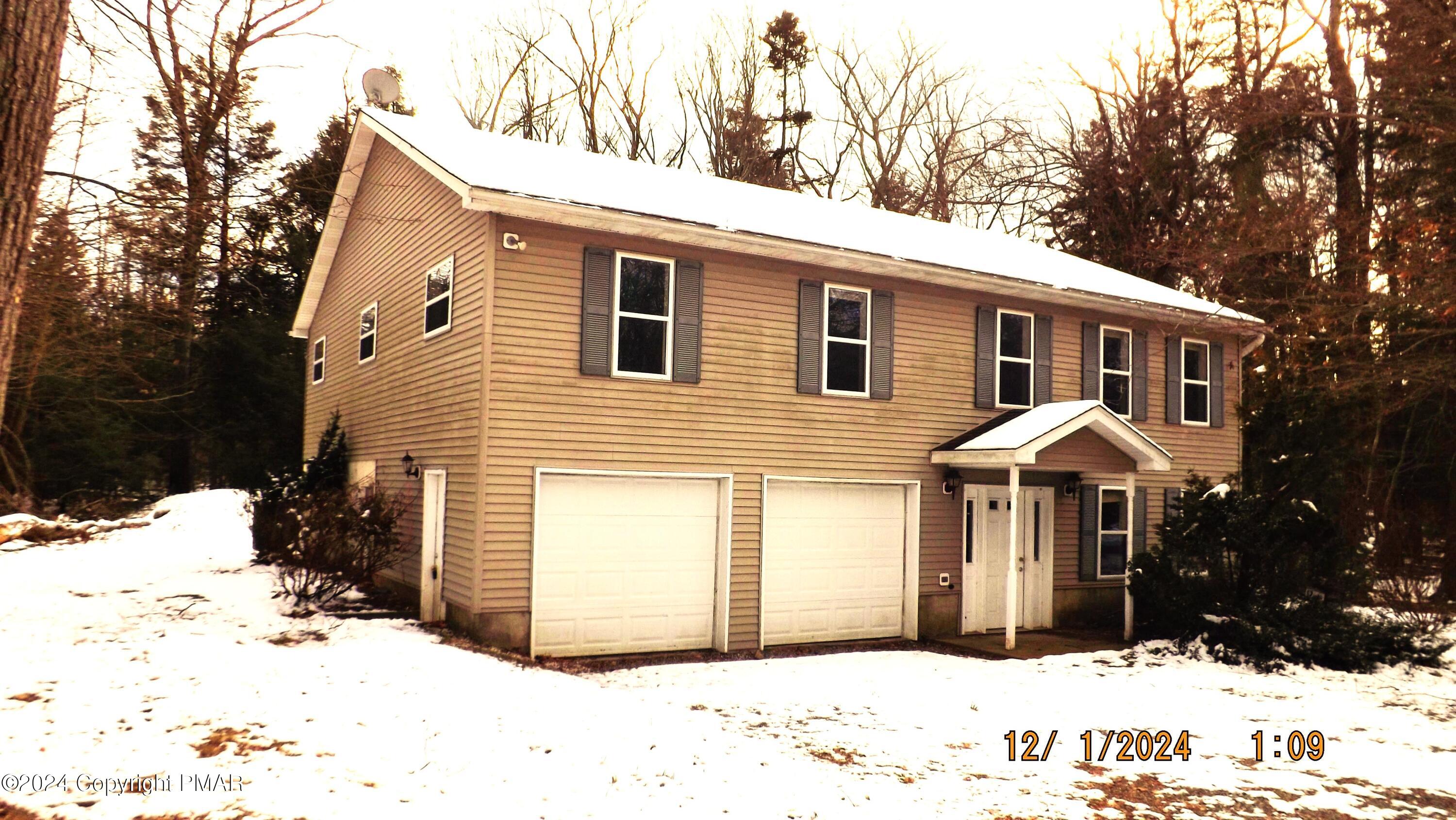 a front view of a house with a yard covered in snow