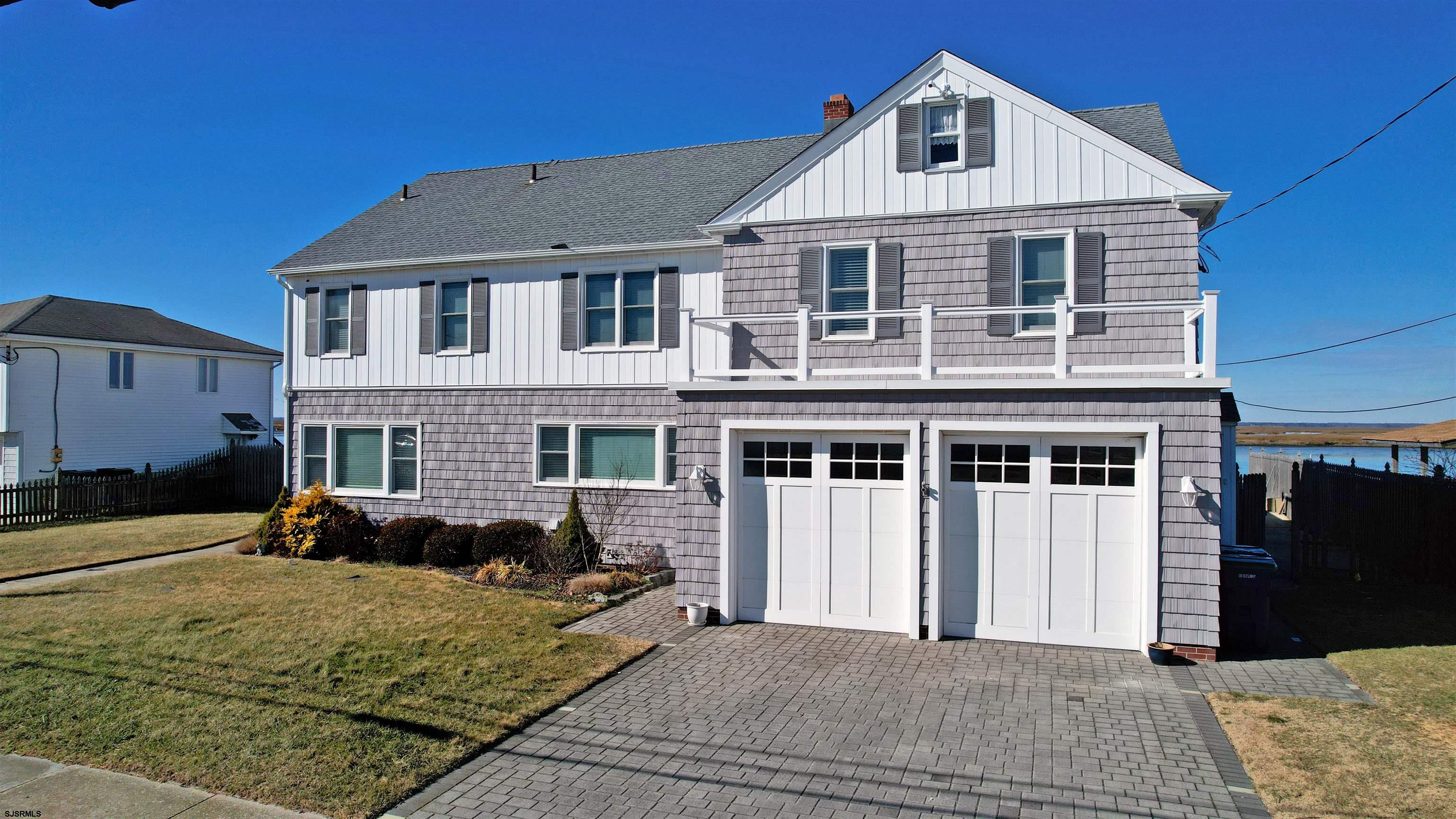 a front view of a house with a yard outdoor seating and garage