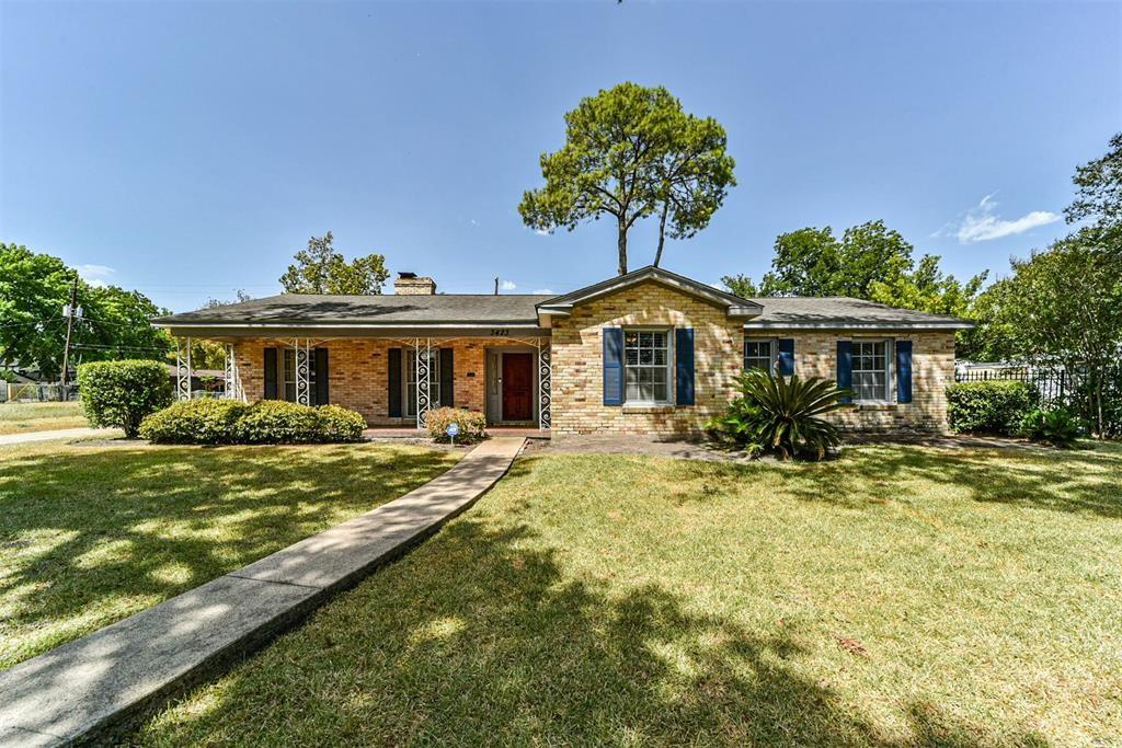 a front view of a house with a yard outdoor seating and covered with trees