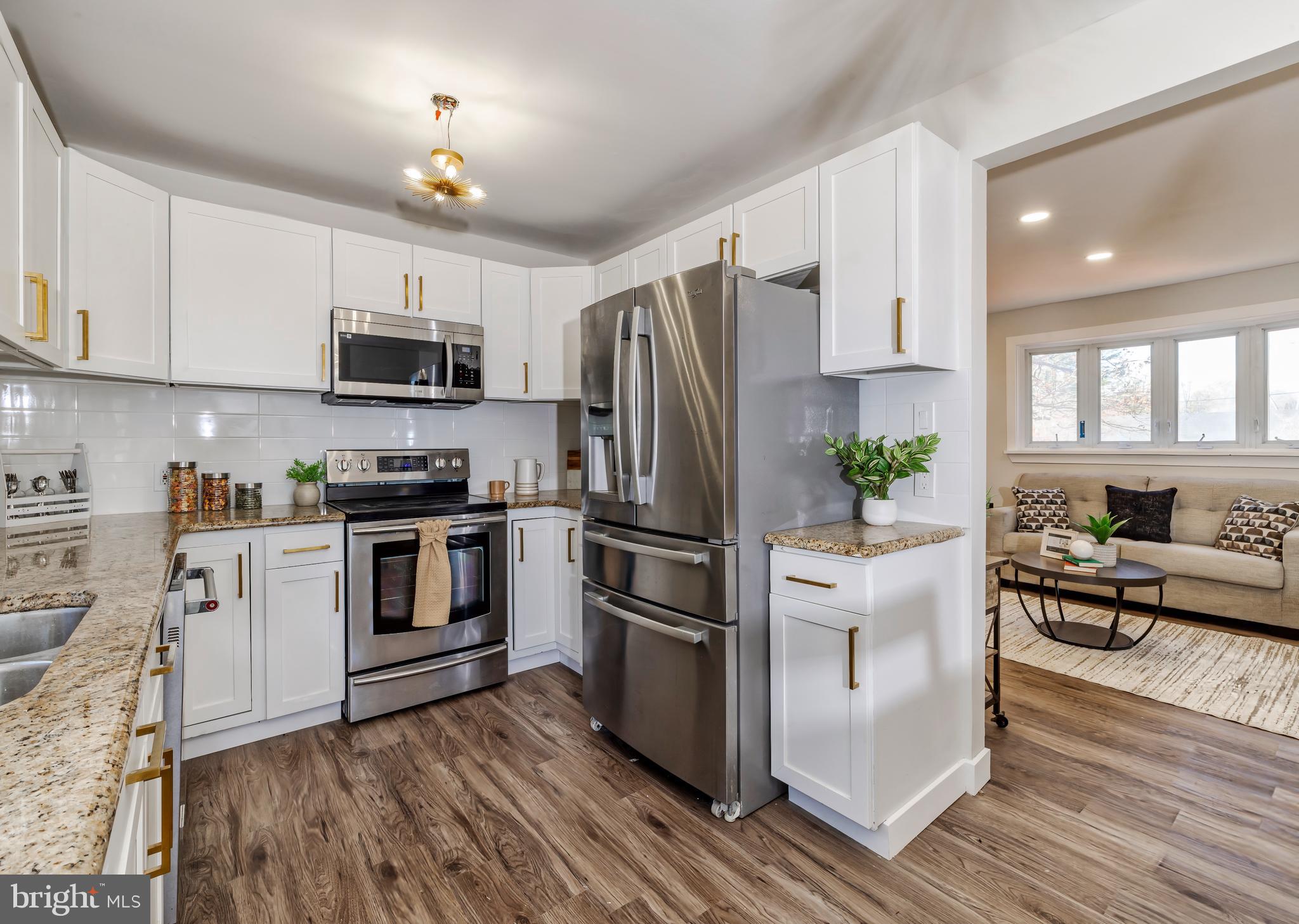 a kitchen with stainless steel appliances a refrigerator sink and microwave