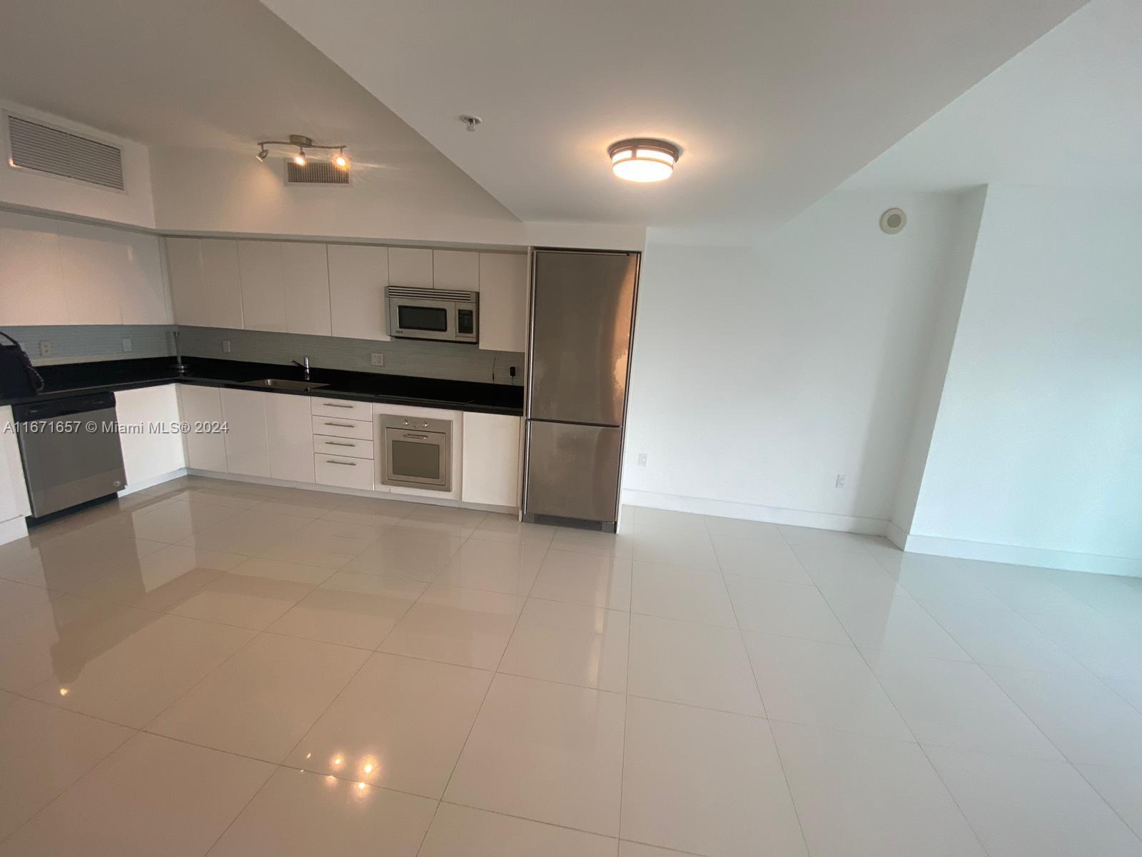 a kitchen with stainless steel appliances a refrigerator and a stove top oven