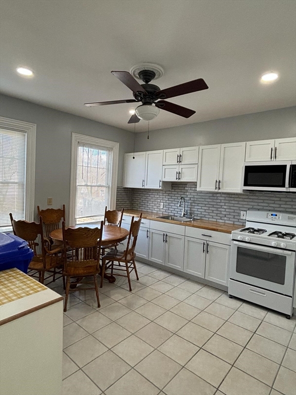 a kitchen with granite countertop cabinets a sink stainless steel appliances and a window