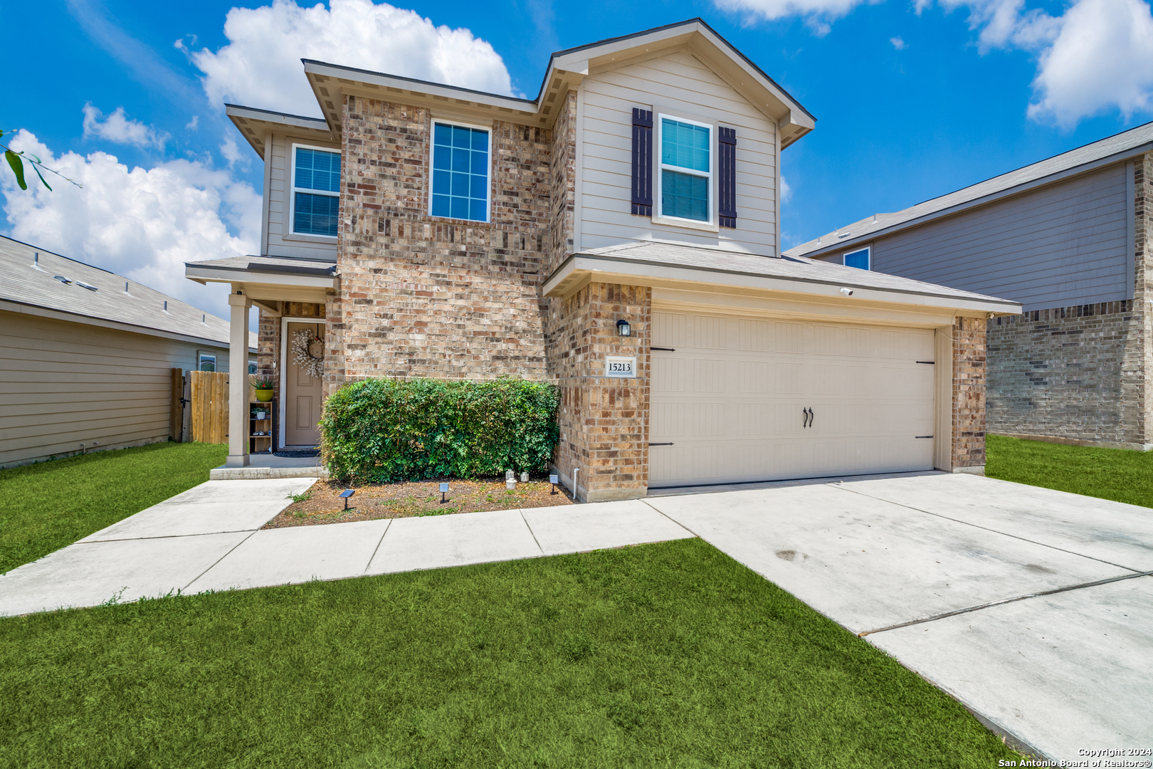 a front view of a house with a yard and garage