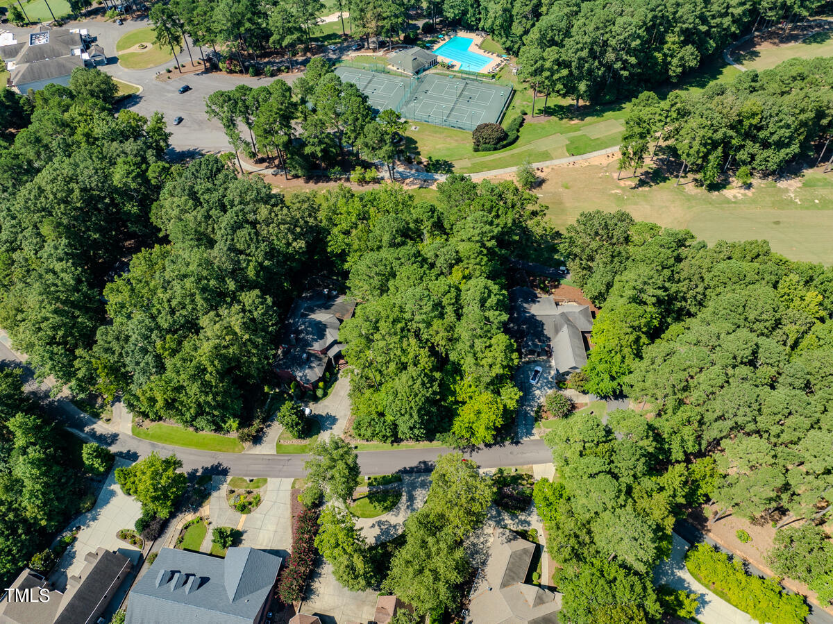 an aerial view of residential house with outdoor space and trees all around