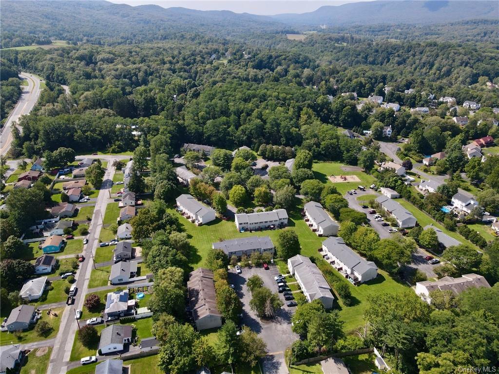 an aerial view of residential houses with outdoor space and trees