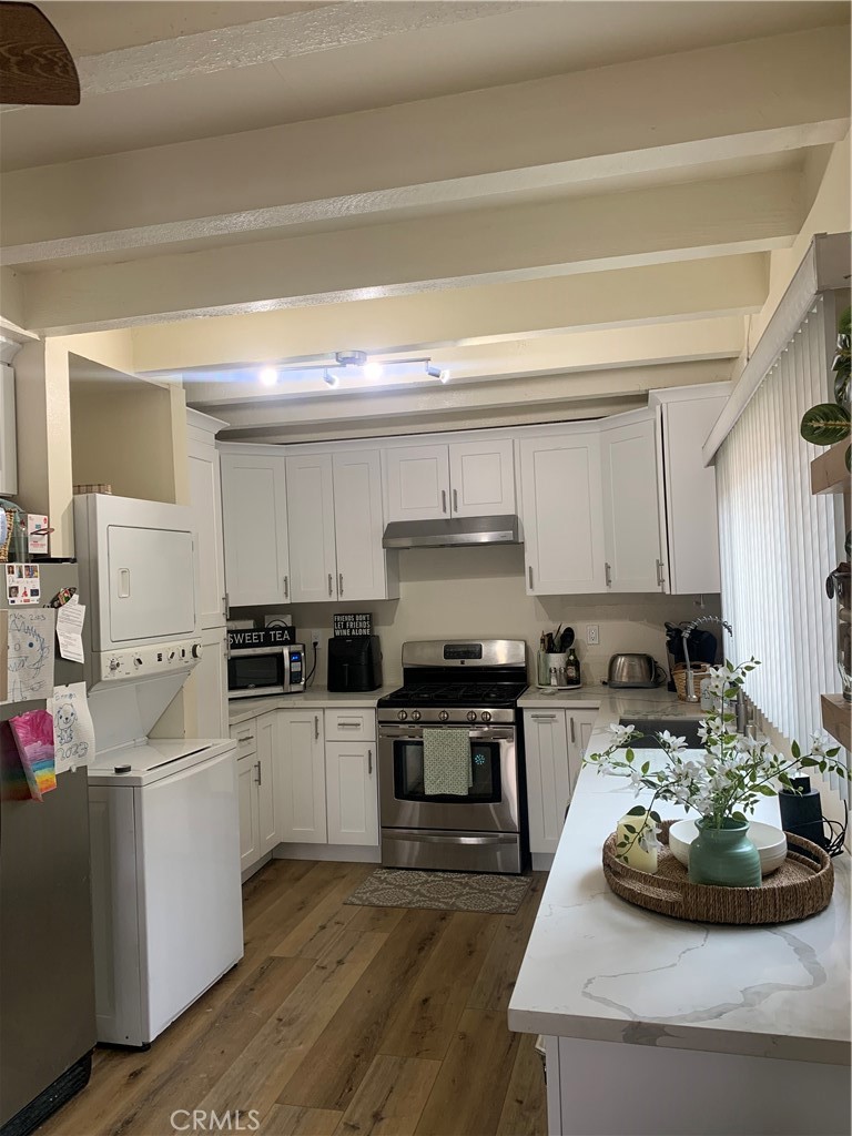 a kitchen with stainless steel appliances a stove a sink and a refrigerator