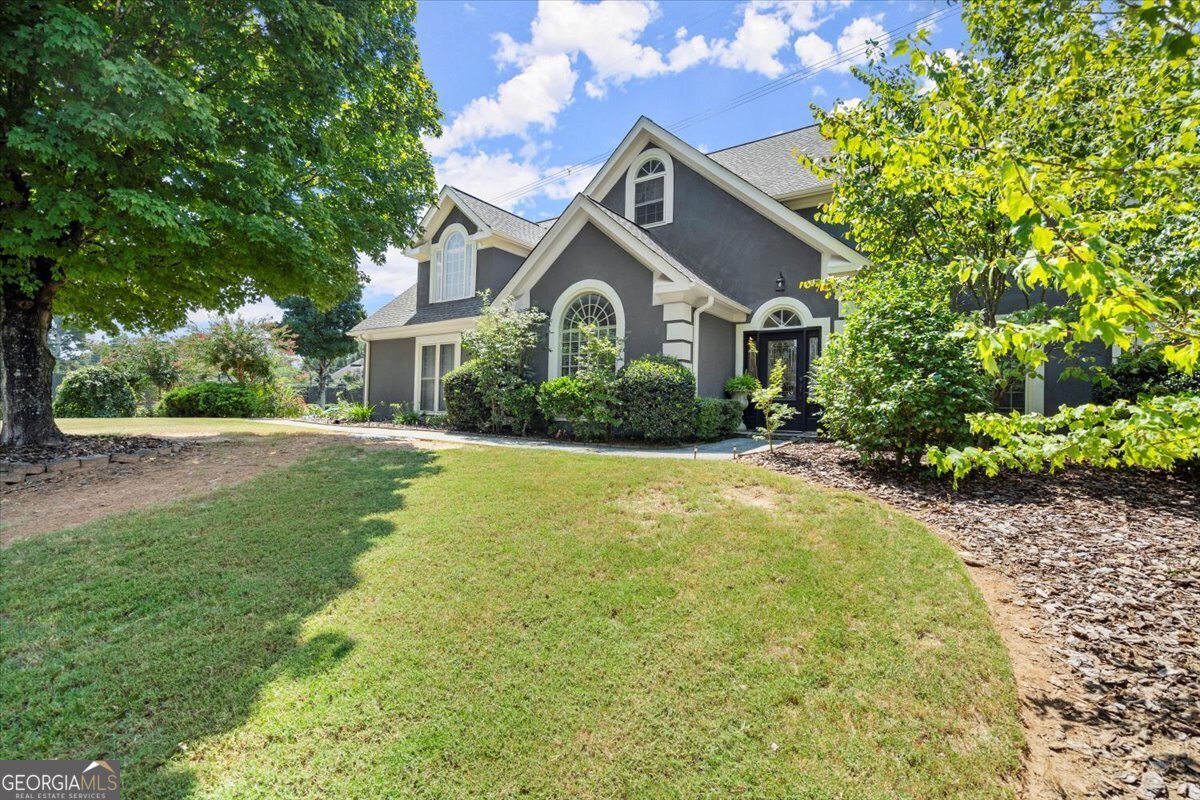 a front view of a house with yard and green space