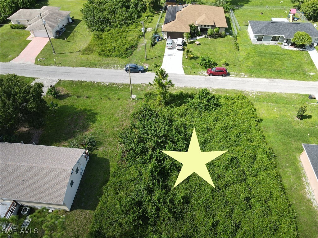 an aerial view of a house with a yard and lake view